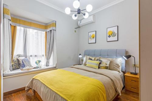 重庆重庆市渝北区·重庆北站·路客精品公寓·00138340的一间卧室配有一张带黄色毯子和窗户的床