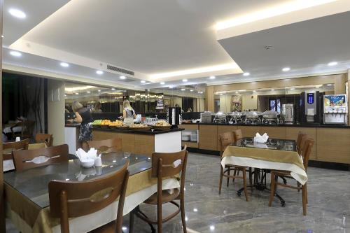伊斯坦布尔NL Amsterdam Hotel的一间带桌椅的餐厅和一间厨房