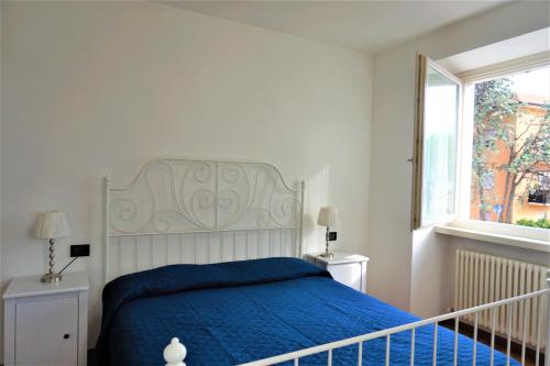 加尔达湖滨Apartment La Coccinella的一间卧室设有蓝色的床和窗户。