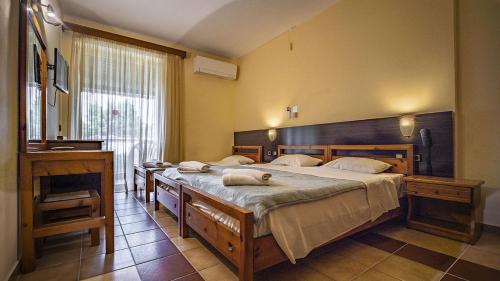 波塞蒂西娅酒店的一间卧室配有两张带毛巾的床