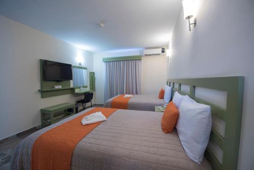 图斯特拉古铁雷斯Hotel Palace Inn的酒店客房设有两张床和一台平面电视。