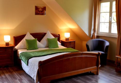 巴登-巴登阿托斯酒店的一间卧室配有一张带绿色枕头的床和一把椅子