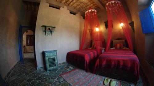 扎古拉Le Sauvage Noble的一间卧室设有两张红色窗帘的床