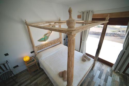 廷达亚Tindaya Nature Home Ocean View的卧室配有带白色床单的木制天蓬床