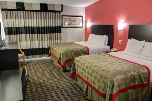 大章克申大章克申华美达酒店的红色墙壁的酒店客房内的两张床