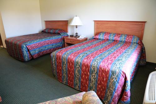 West Point地平线套房汽车旅馆的酒店客房设有两张床和一张桌子。