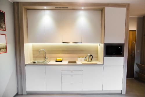 威利兹卡ULMA apartment的厨房配有白色橱柜和水槽
