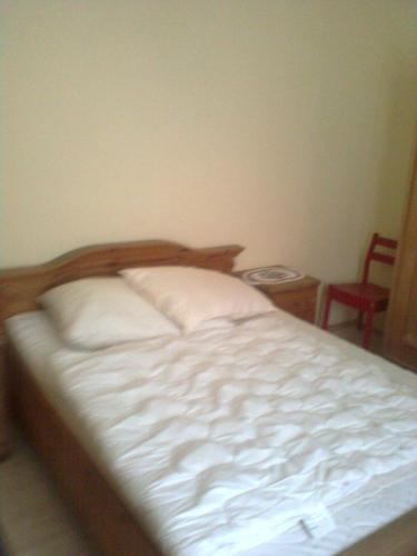 HörbingGasthof Weingut Brand Walter的一间卧室配有一张带白色床单和椅子的床