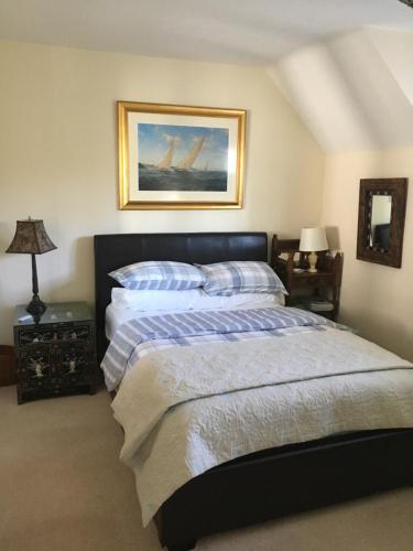 考斯Cowes - The Barn的卧室配有一张床,墙上挂有绘画作品