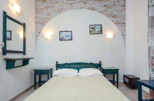 圣安娜纳克索斯波尔密斯套房公寓的一间卧室配有一张带两张绿色桌子的床