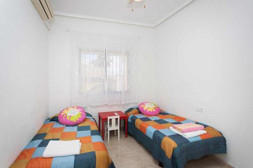 克萨达城CH Villa Isla Menorca Ciudad Quesada的一间设有两张床和一张桌子的房间