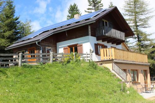 圣科卡瑟林奥夫Gartenwohnung auf der Sommeralm的山顶上带太阳能屋顶的房子
