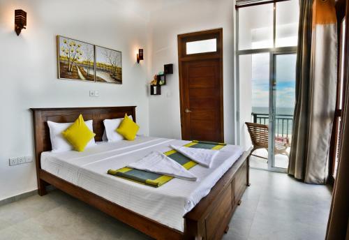 希克杜沃Rominrich的一间卧室配有一张带黄色枕头的床和一扇窗户