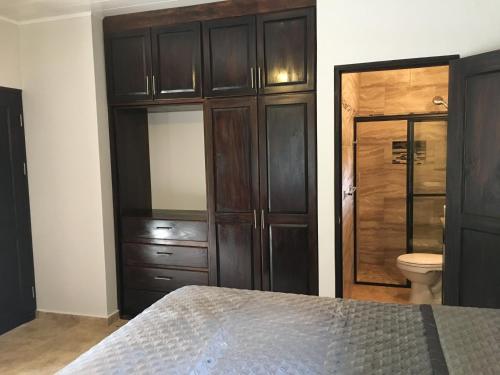 下博克特Finca Caramelo的一间卧室配有一张床、一个卫生间和橱柜