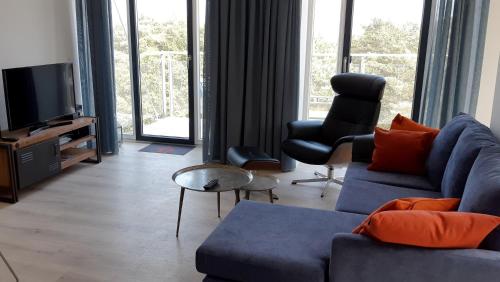 宾茨Ferienwohnung Albatros的客厅配有蓝色的沙发和电视