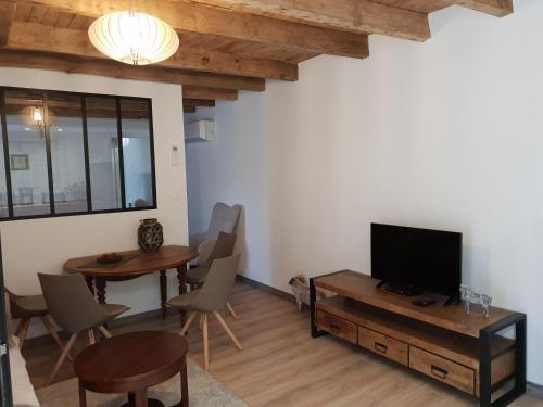 萨尔拉拉卡内达Studio Fontaine d’amour的客厅配有电视和桌椅