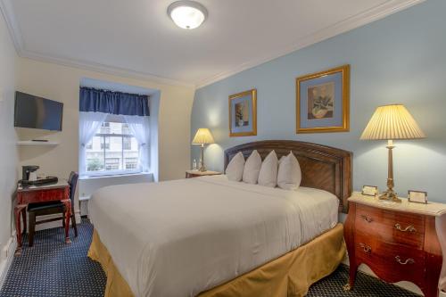 纽约西部三号俱乐部酒店的酒店客房设有一张大床和一张书桌。