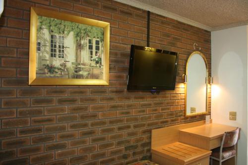 墨尔本Arden Motel的墙上的砖墙和平面电视