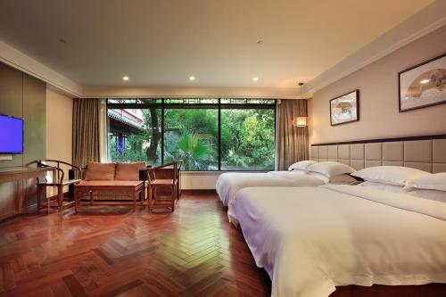 桂林桂林訾洲四景度假酒店的酒店客房设有三张床和电视。