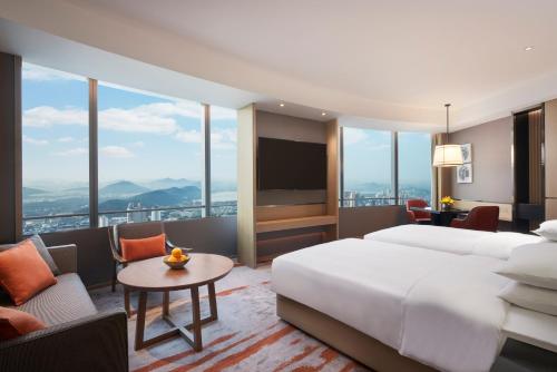 徐州徐州苏宁凯悦酒店的酒店客房配有床、沙发和电视。