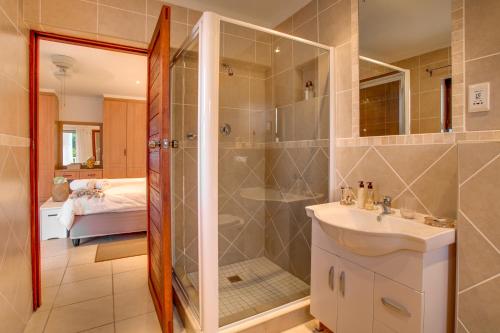 普利登堡湾Limoni Luxury Suites的带淋浴和盥洗盆的浴室