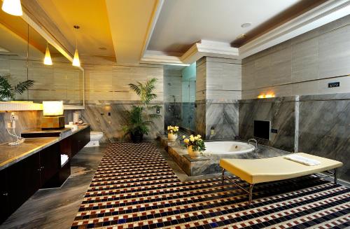 台南京华商务汽车旅馆的带浴缸、水槽和桌子的浴室