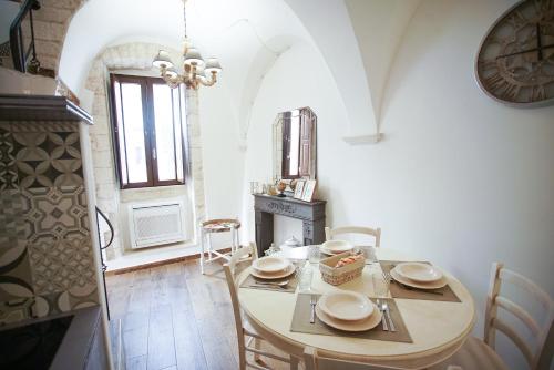 普蒂尼亚诺Dimora Maestà的一间带桌椅和时钟的用餐室