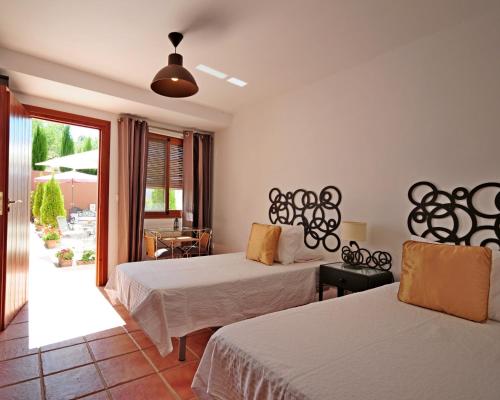 LecrinLa Fuente Retreat的酒店客房设有两张床和一个阳台。