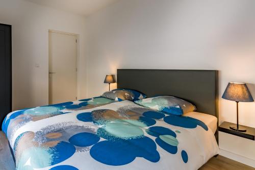 法尔肯堡Boven de ijsjes的一间卧室配有一张带蓝色和白色棉被的床