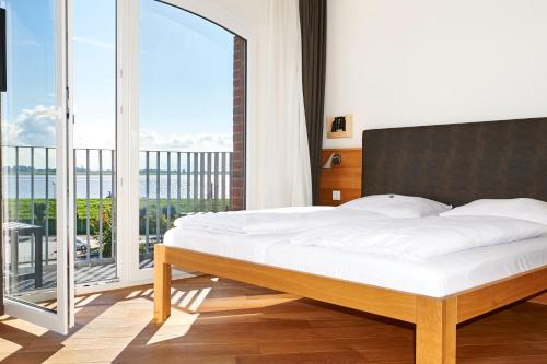 不来梅港布莱梅因杰赫酒店的一间卧室设有一张大床和一个大窗户