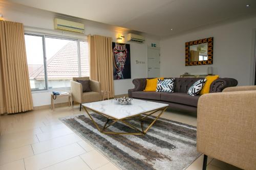阿克拉The Avery Apartments, Dzorwulu的带沙发和咖啡桌的客厅