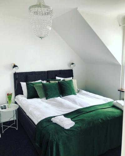 TabergHotell Taberg的一间卧室配有一张带绿色枕头的大床