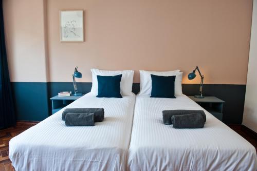 里斯本White Wine Lovers Apartment 5B的一间卧室配有两张带蓝色枕头的床。