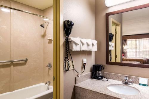 帕里斯德克萨斯帕里斯品质酒店的一间带水槽和镜子的浴室以及一部电话