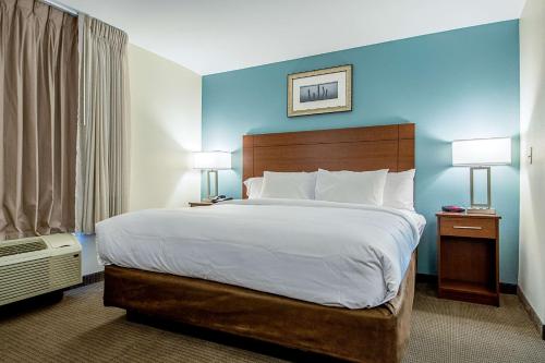 GeismarMainStay Suites Geismar - Gonzales的一张大床,位于酒店带两盏灯的房间