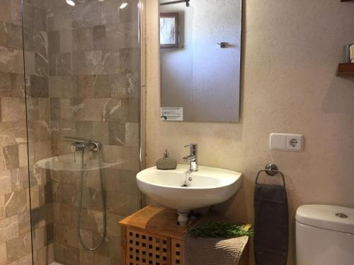锡内乌Sa Estada的浴室配有盥洗盆和带镜子的淋浴