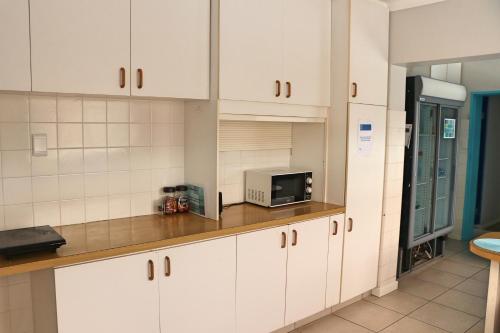 开普敦MoTown by Mojo的厨房配有白色橱柜和微波炉