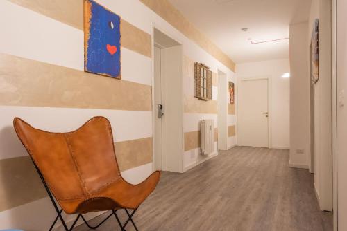 贝加莫Maison Castelli的走廊上的椅子,墙上有绘画作品