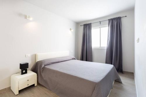 阿罗纳Torres del Sol的白色的卧室设有床和窗户