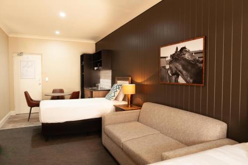 诺拉Nightcap at Archer Hotel的酒店客房,配有床和沙发