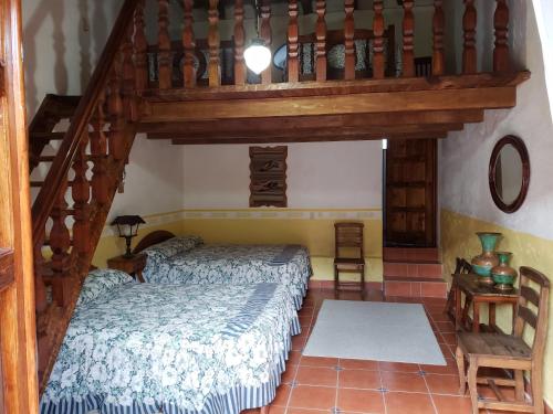 San Lorenzo SoltepecEx-Hacienda San Buenaventura的一间卧室设有一张床和木制楼梯。