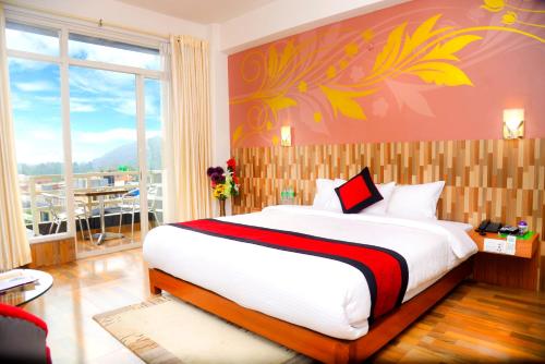 博卡拉Hotel City Inn - Mountain View的一间带大床的卧室和一个阳台