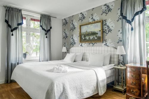 DejeDömle Herrgård Spa & Resort的卧室配有白色床和蓝色花卉壁纸