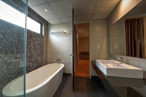莎阿南莎阿南阿卡贝拉套房酒店的带浴缸和盥洗盆的浴室