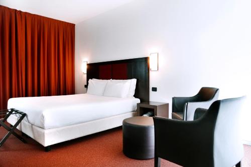 维洛尔巴假日拉马卡酒店的配有一张床和一把椅子的酒店客房