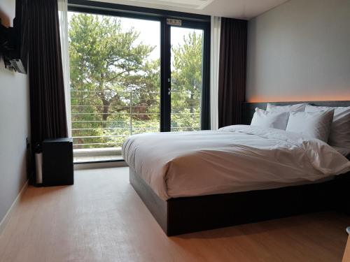 釜山Suntree Hotel的一间卧室设有一张大床和一个大窗户