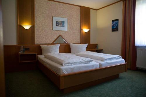 霍夫格鲁纳灵德兰德酒店的卧室配有带白色枕头的大床
