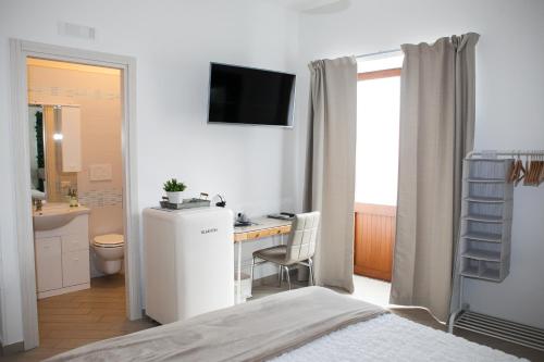 索伦托Vicolo 8的一间卧室配有一张床、一张书桌和一台电视