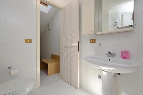 利尼亚诺萨比亚多罗帕尔科海明威公寓的白色的浴室设有水槽和卫生间。
