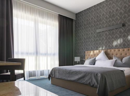 吕讷堡anders Kontorhaus Hotel的一间卧室配有一张床、一张书桌和一个窗户。